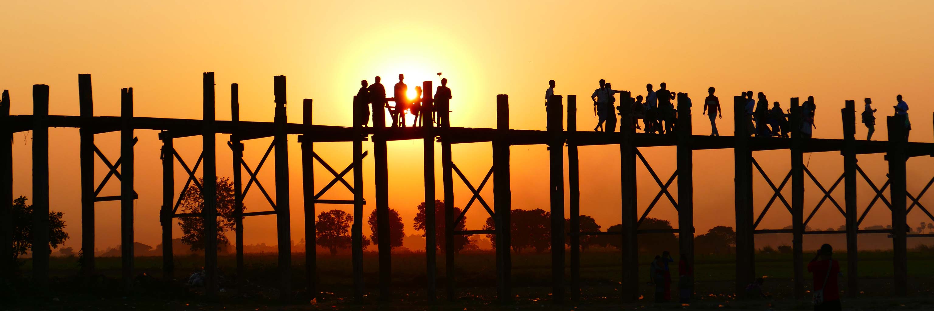 People on bridge during sunset